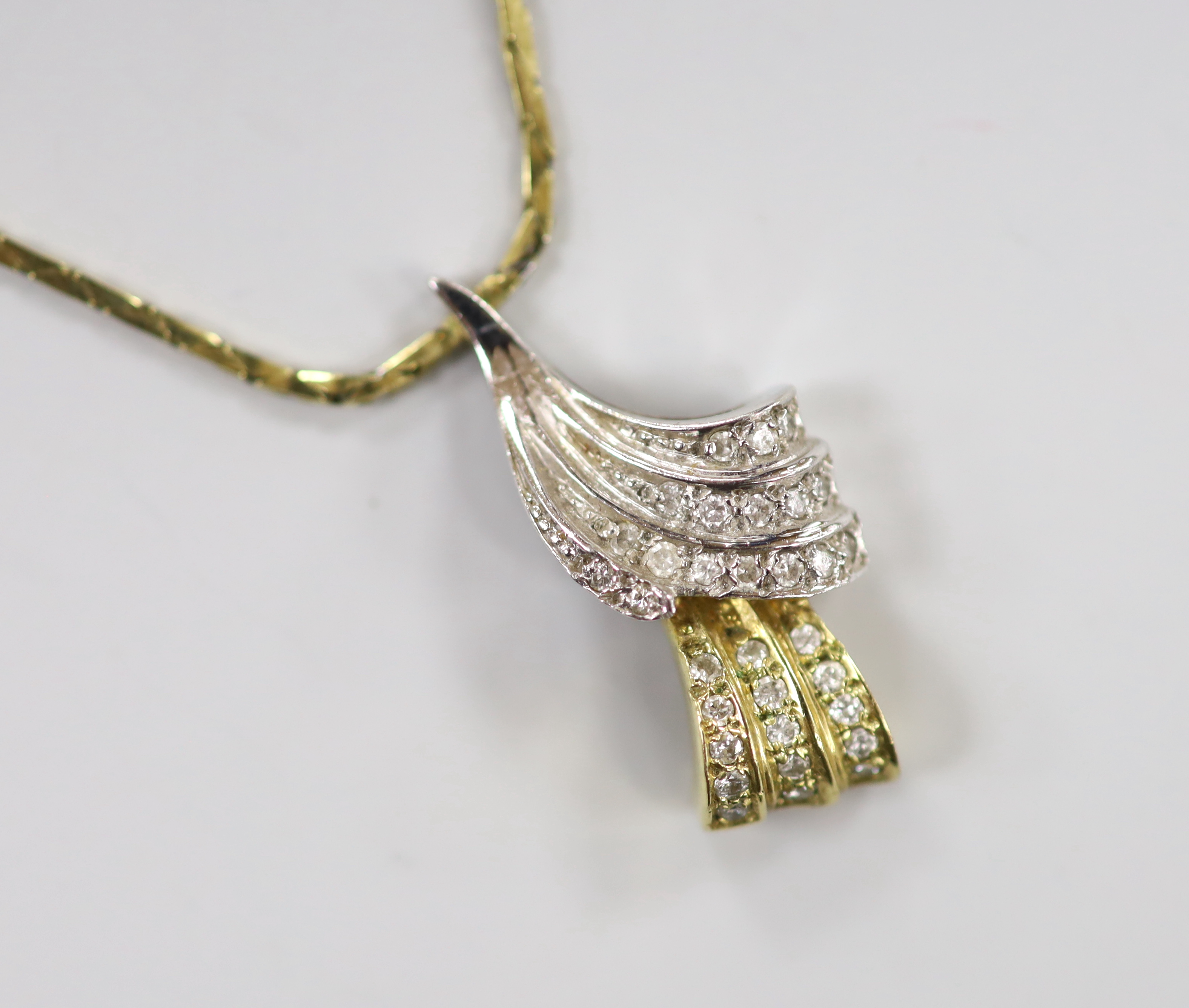 A modern two colour 9ct gold and diamond chip set double scroll pendant necklace, overall 44cm, gross weight 7.4 grams.